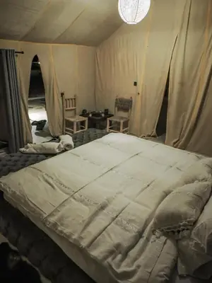 a bedroom with a large bed in a tent at SAHARENA Camp in Merzouga