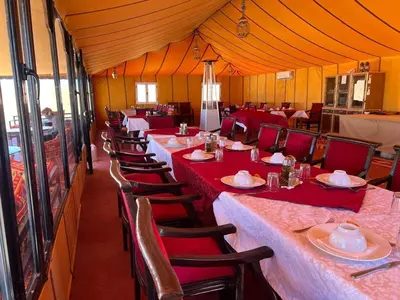 a row of tables and chairs in a large tent at SAHARENA Camp in Merzouga