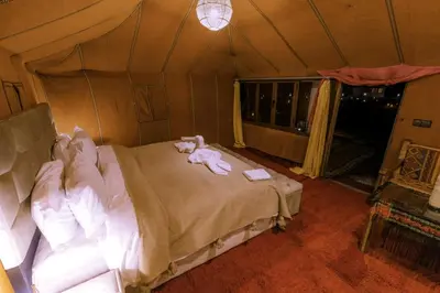 a bedroom with a bed in a tent at SAHARENA Camp in Merzouga