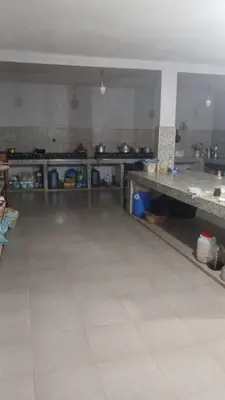 a large kitchen with a white tiled floor at Merzouga Sunshine traditional luxury camp in Merzouga