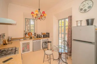 a kitchen with a refrigerator and a table and chairs at Beautiful Boccara villa, 4 suites and private pool in Chaibate