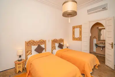 two beds with orange sheets in a bedroom at Beautiful Boccara villa, 4 suites and private pool in Chaibate
