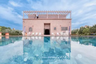 a swimming pool with chairs in front of a building at Villa Memories 5bedrooms Space, laughter, relaxation in Marrakesh in Douar bel Rhanodour