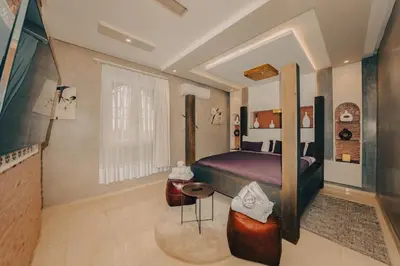 a bedroom with a bed and a table in it at Villa Memories 5bedrooms Space, laughter, relaxation in Marrakesh in Douar bel Rhanodour