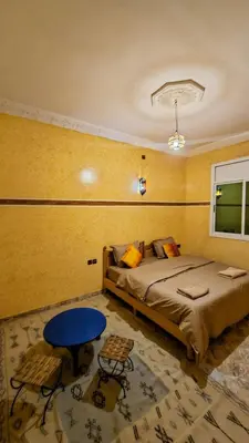 a bedroom with a bed and a blue table at luxury desert house merzouga 3BR 2 terraces in Merzouga