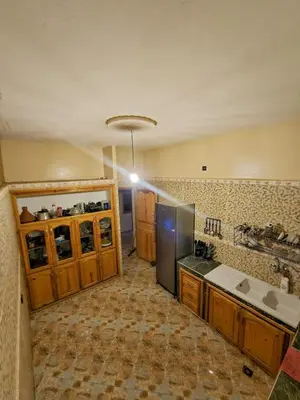 a kitchen with wooden cabinets and a stainless steel refrigerator at luxury desert house merzouga 3BR 2 terraces in Merzouga