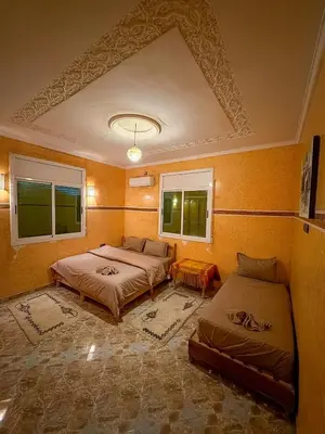 a bedroom with two beds and two windows at luxury desert house merzouga 3BR 2 terraces in Merzouga