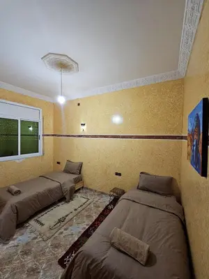 three beds in a room with yellow walls at luxury desert house merzouga 3BR 2 terraces in Merzouga