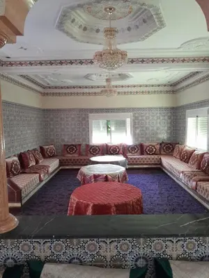 a living room with couches and a chandelier at maison marocaine atlas in Tinerhir