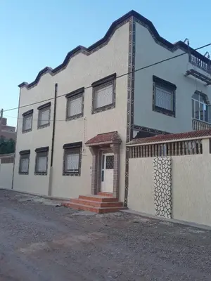 a large white building with a porch and a door at maison marocaine atlas in Tinerhir