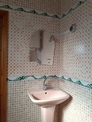 a bathroom with a sink and a mirror at maison marocaine atlas in Tinerhir