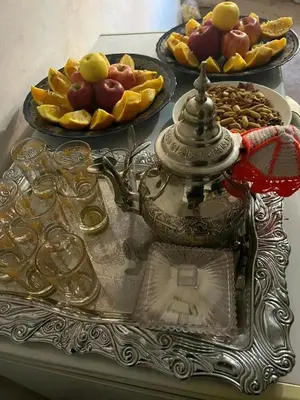 a table with a tray of fruit and a tea kettle at Gîte Chez habitant in Telouet