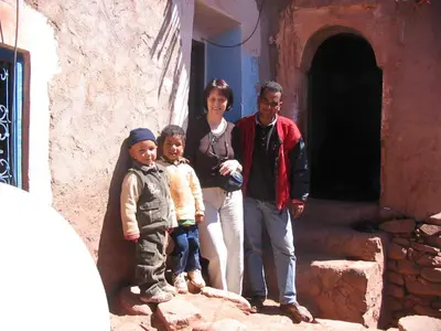 a man and two children standing next to a building at Gîte Chez habitant in Telouet