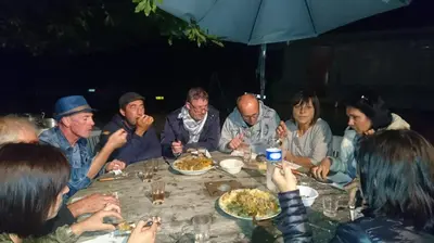 a group of people sitting around a table eating food at Gîte Chez habitant in Telouet