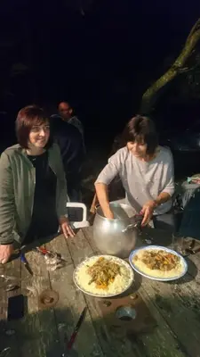 two women are preparing pizzas on a wooden table at Gîte Chez habitant in Telouet