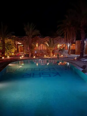 a large swimming pool at night at Hotel oasis merzouga in Merzouga