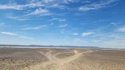 a person walking on a sandy beach near the water at Hotel oasis merzouga in Merzouga
