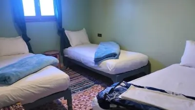 a room with three twin beds and a window at KasbatTaslit in Ouarzazate