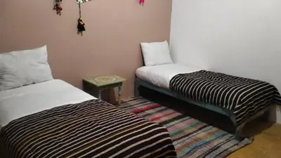 two beds sitting next to each other in a room at KasbatTaslit in Ouarzazate