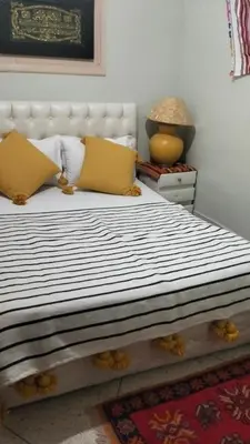 a bedroom with a large bed with yellow pillows at KasbatTaslit in Ouarzazate