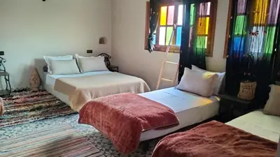 two beds in a room with stained glass windows at KasbatTaslit in Ouarzazate