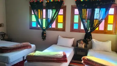 two beds in a room with stained glass windows at KasbatTaslit in Ouarzazate