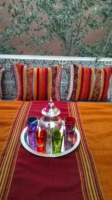 a tray with four different colored glasses on a table at KasbatTaslit in Ouarzazate