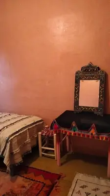 a room with a mirror and a bed and a chair at KasbatTaslit in Ouarzazate