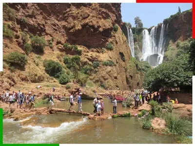 a group of people standing in the water near a waterfall at Cozy Apartment Near Ouzoud Waterfalls in Azilal