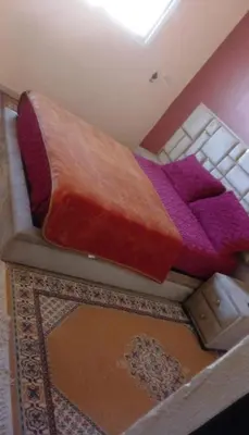 a bed with a blanket on top of it at Cozy Erfoud apartment - Moroccan charm & comfort in Erfoud
