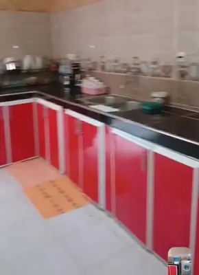 a kitchen with red cabinets and a counter top at Cozy Erfoud apartment - Moroccan charm & comfort in Erfoud