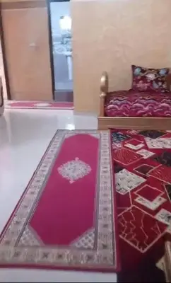 a bedroom with a bed and a red rug at Cozy Erfoud apartment - Moroccan charm & comfort in Erfoud