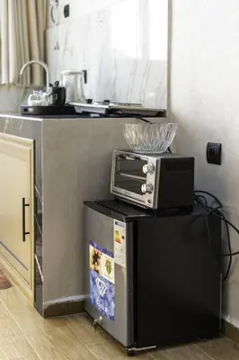 a kitchen with a toaster oven on top of a refrigerator at Mina Home 2 in Oulad Akkou