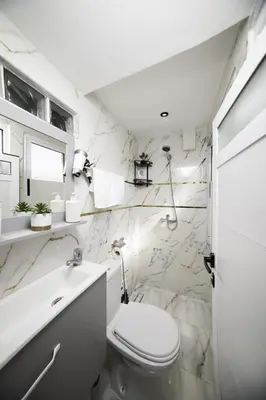 a white bathroom with a toilet and a sink at Mina Home 2 in Oulad Akkou