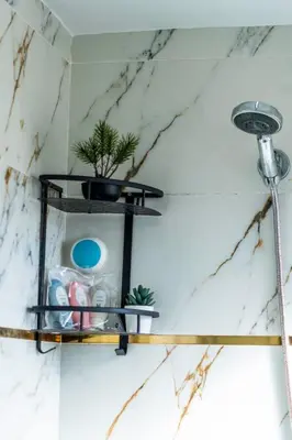 a bathroom with a black shelf on the wall at Mina Home 2 in Oulad Akkou