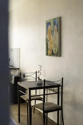 a dining room table and chairs with a painting on the wall at Mina Home 2 in Oulad Akkou