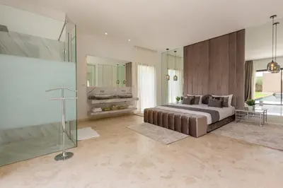 a bedroom with a large bed and a glass wall at Villa Ambre in Marrakech
