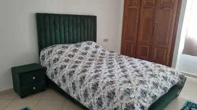 a bed with a comforter on it in a bedroom at Luxurious Accessible Apartment in the Heart of Fes in Fès