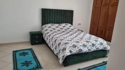 a bedroom with a bed with a comforter and a mirror at Luxurious Accessible Apartment in the Heart of Fes in Fès