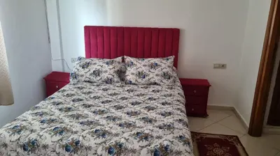 a bed with a floral comforter and two pillows at Luxurious Accessible Apartment in the Heart of Fes in Fès