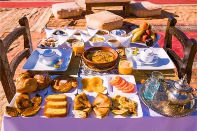 a table with a blue table cloth with food on it at Andromeda Sahara Camp in Merzouga