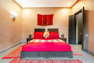 a bedroom with a large red bed with red pillows at Villa Tamara luxury villa private pool Marrakech in Najem