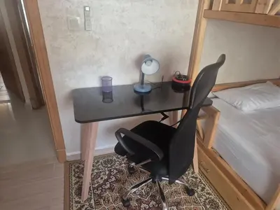 a desk with a lamp and a chair next to a bed at Maison intelligente, idéale pour les familles avec Netflix, parking et ascenseur in Fès
