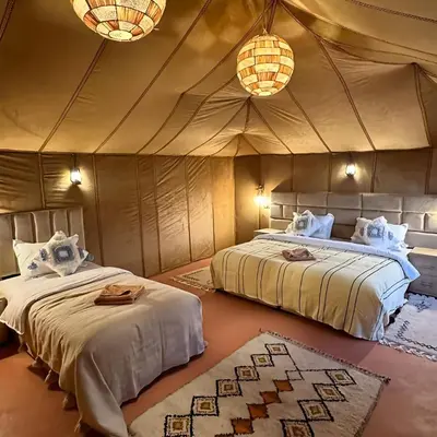 a bedroom with two beds in a tent at Sahara Spirit Luxury Camp in Merdani