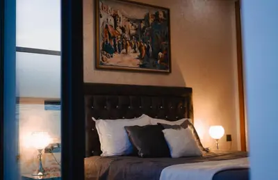 a bedroom with a bed with a painting on the wall at Appartement de luxe avec piscine - Agadir Bay in Oulad Akkou