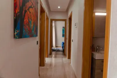 a hallway with a sink and a painting on the wall at Appartement de luxe avec piscine - Agadir Bay in Oulad Akkou