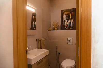 a bathroom with a sink and a toilet and a mirror at Appartement de luxe avec piscine - Agadir Bay in Oulad Akkou