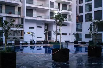 an apartment building with trees in a courtyard at Appartement de luxe avec piscine - Agadir Bay in Oulad Akkou