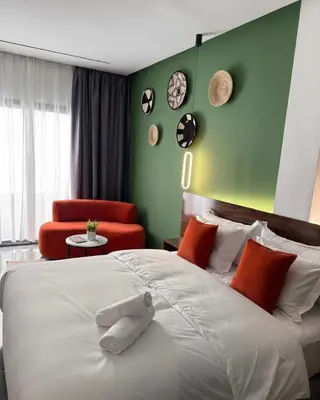 a bedroom with a large white bed and a red chair at PAUSE HOUSE-Downtown-Front of Station-Airport Bus-FREE COUSCOUS Friday in Fès