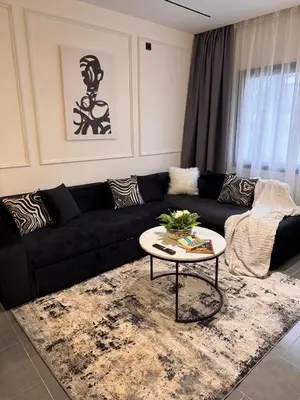 a living room with a black couch and a table at PAUSE HOUSE-Downtown-Front of Station-Airport Bus-FREE COUSCOUS Friday in Fès